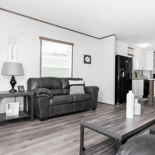 This open floorplan living room in [model name] has beautiful wood style floors and cool tone features.