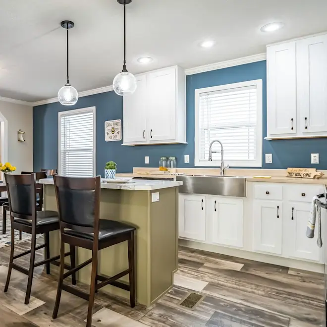 This incredible Brookline Flex 32 Wide kitchen has it all: white cabinets, hanging pendant lights, kitchen island and hardwood style tiling.