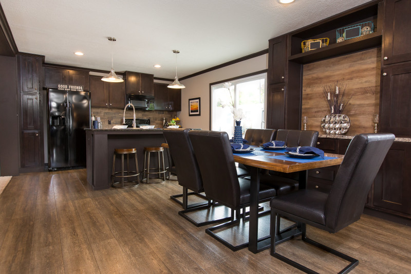 A manufactured home dining area and kitchen with built-in cabinetry and a large breakfast bar.