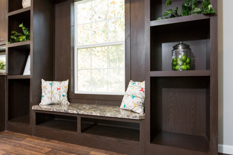 Built-in window seating made from dark toned wood with green accent decorations