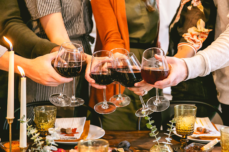 Guests in a manufactured home kitchen drinking out of glasses.
