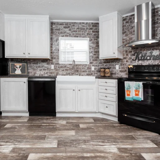 We love this [model name] kitchen which has an industrial look with its brick style backsplash, stainless steel oven hood and metallic finishes.