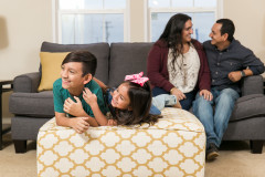 Family sitting on a couch in a Clayton Home center.