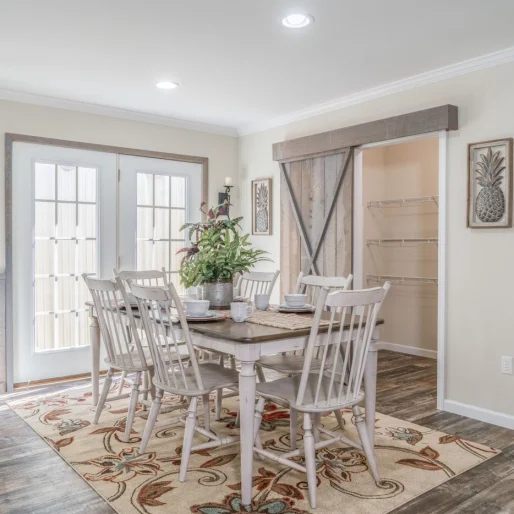 Modern touches help The [model name]'s dining room stand out. With plenty of natural light, light colored floors and a sliding barn door, this dining room is stylish, modern and functional.