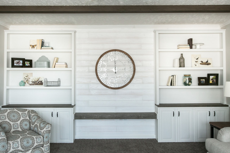 Manufactured home built-in entertainment center shiplap features and custom bookshelves.