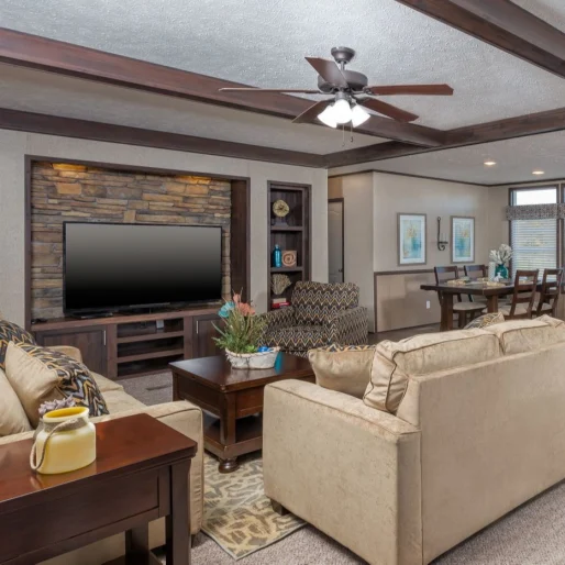 This spacious and eclectic living room can be found in our [model name] home. The stacked stone storage cabinets complete with TV cutout pair well in this spacious and stylish living room.