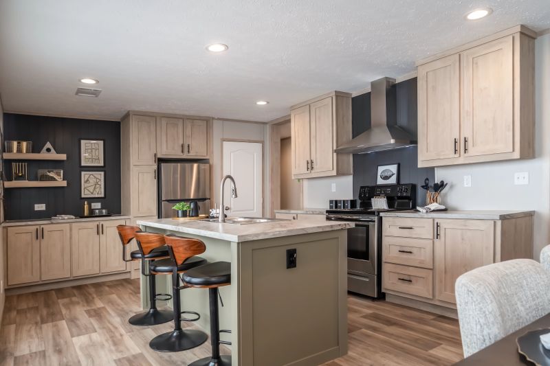 There's a white and tan kitchen with dark gray paneling as backslash. It has a green breakfast bar island in the center of the room.