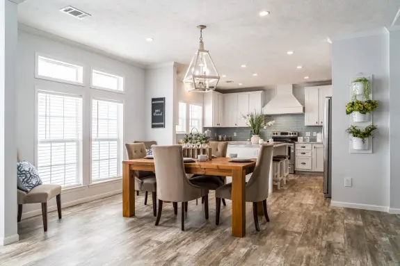 Enjoy family dinners in The Ingram light and airy open floor plan dining room with a lantern-style chandelier, large windows, crown molding and easy access to the kitchen with its large island and beautiful backsplash.