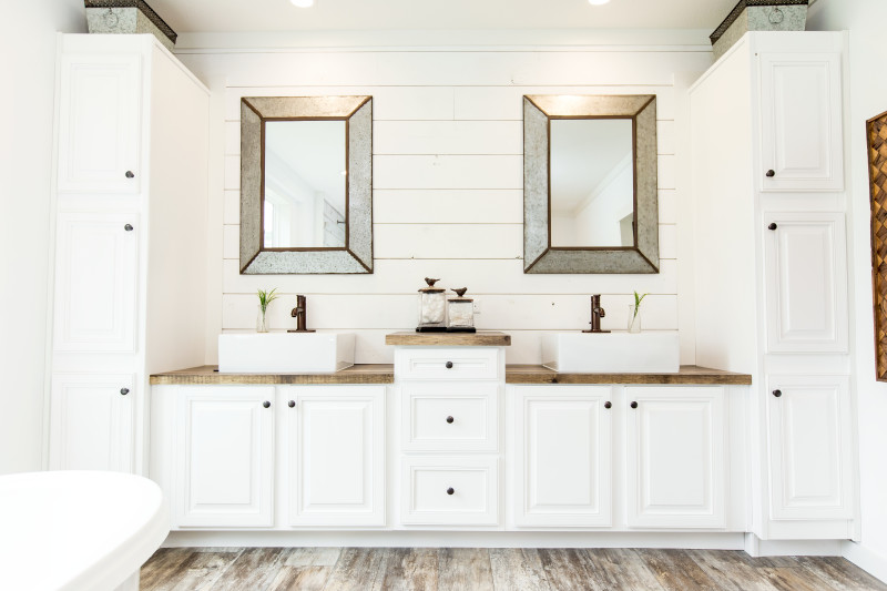 Manufactured home master bathroom with double sinks and white cabinetry.