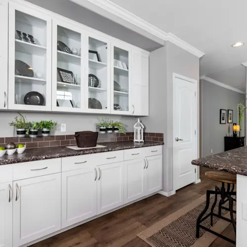 The kitchen of Enchantment 3070A offers you tons of shelves and cabinets, along with a place to set out food, next to the pantry.