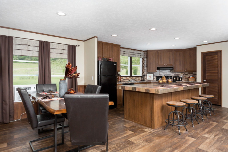 Trendy kitchen and dining room connected via an open floor plan of a manufactured modular home.