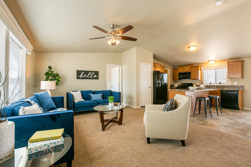 An open floor plan living room and kitchen in The Wave manufactured home model.