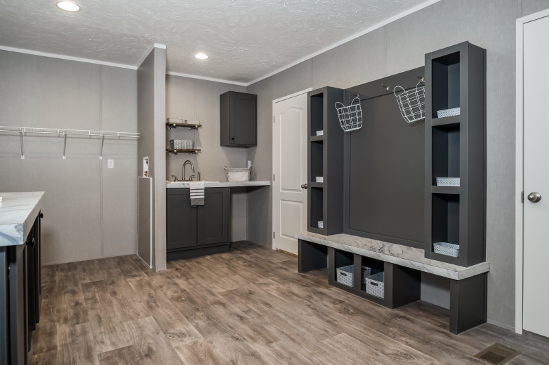  Laundry room with drop zone, sink, cabinets, and folding area