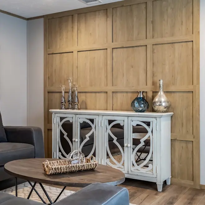 The highlight of this home's living room is the light wood accent wall. The space also features tons of natural light and an open floor plan into the kitchen.