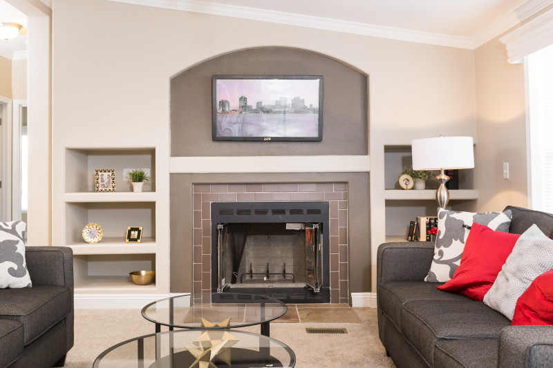 Manufactured home living room with an entertainment center and brick fireplace.