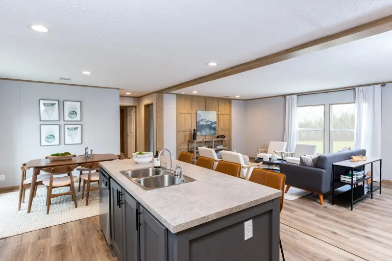 The Rio by Clayton is part of the manufactured home Adventure Series, featuring an open layout with a long kitchen island and an accent wall in the living room. 
