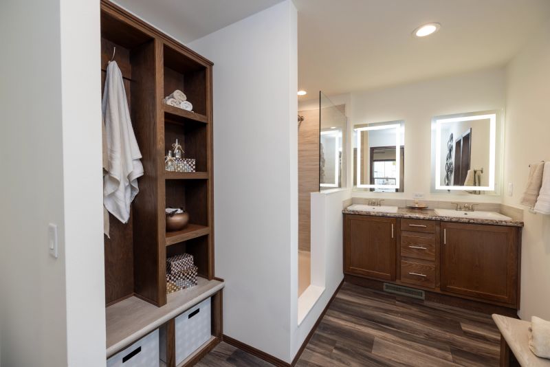 Bathroom in manufactured home with a built-in cubby for storage, double vanity, and walk-in shower.