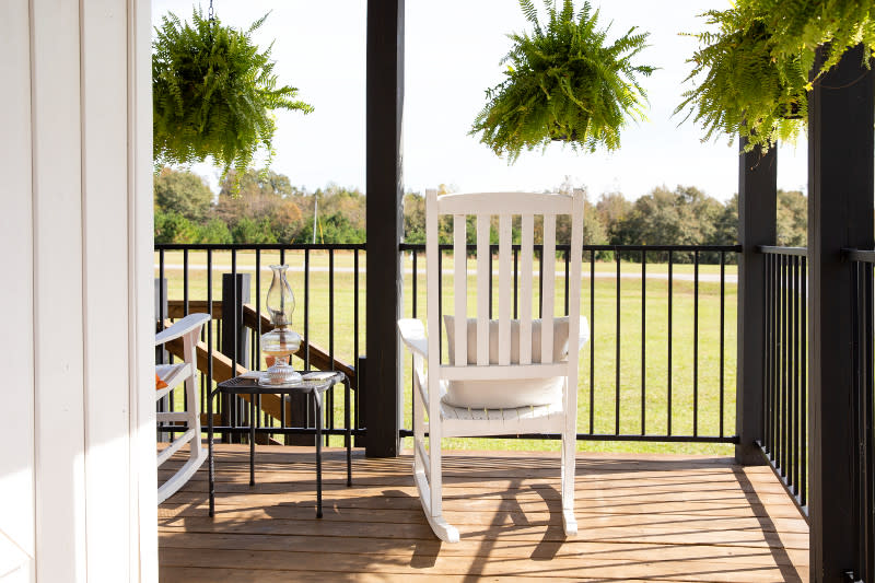 White rocking chair on a manufactured home covered porch looking over the homeowner's property.