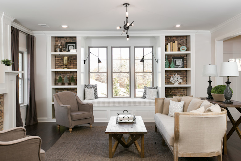 Manufactured home living room with large windows and stone book shelves.