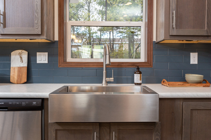 A stainless steel farmhouse style kitchen sink in a manufactured home.