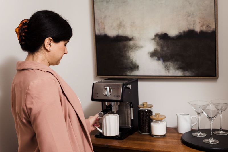 A woman uses a coffee maker at a coffee bar in a manufactured home