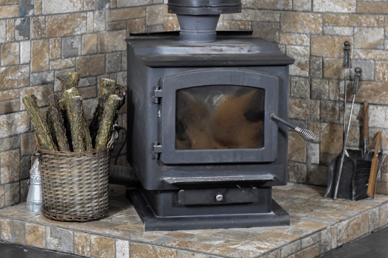 Black wood burning fireplace with wicker basket to the left holding wood logs