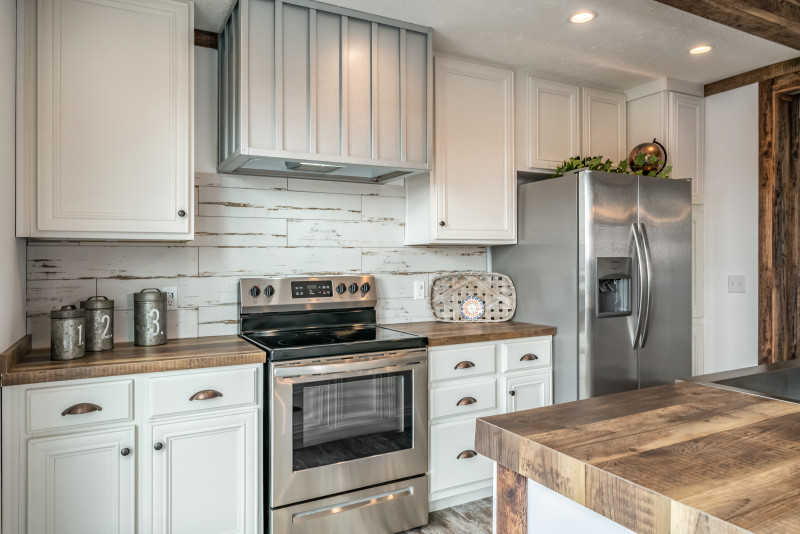 Kitchen of the Avalyn displaying white cabinets and wooden countertops.