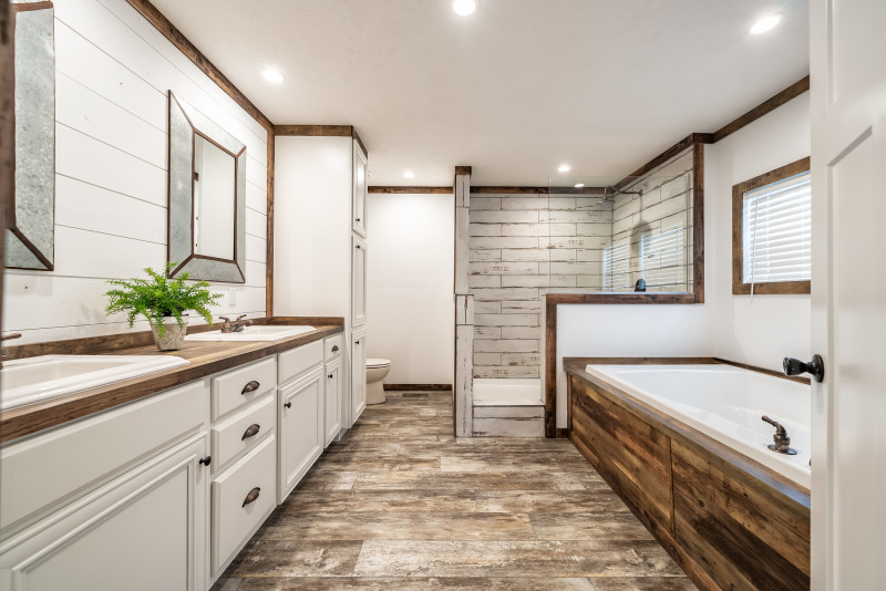Primary bathroom of the Avalyn with large soaker tub, walk-in shower and white cabinets.