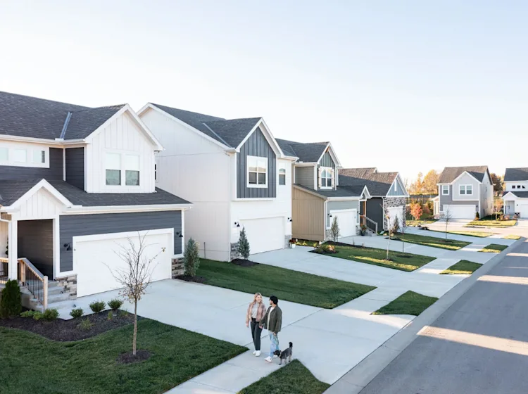 Couple walks their dog in a new construction site built neighborhood.