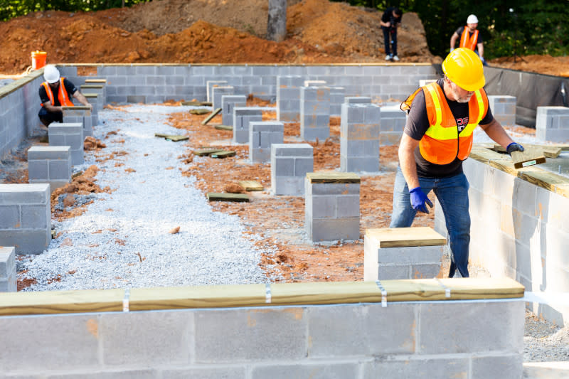 Workers installing the foundation of a CrossMod home.