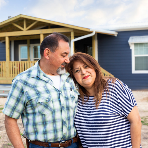 Moraima and Roland Duran stand outside of their ranch style Clayton manufactured home exterior in Texas.