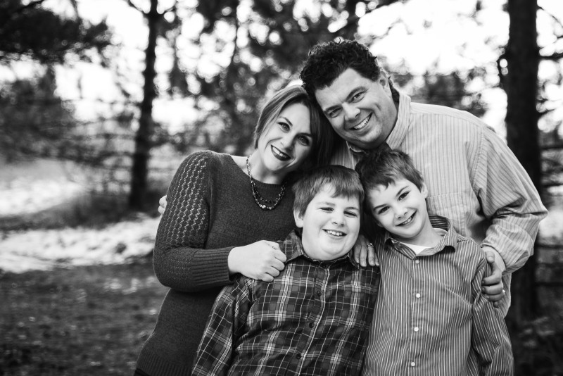 Black and white family photo of clayton employee, her husband and two young boys.