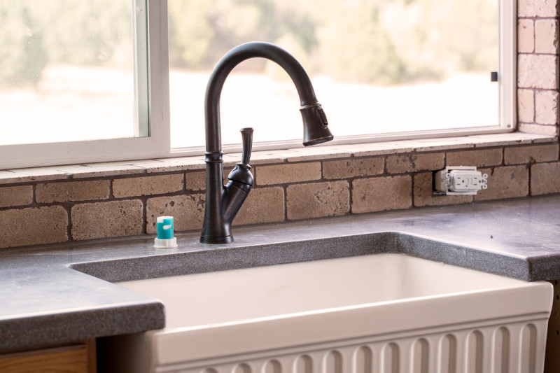 Farmhouse sink in with a decorative ceramic basin set in a grey counter top.