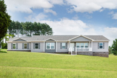 Exterior of a Clayton manufactured home with a gray roof, light gray siding, gray shutters and white trim, with a small front porch