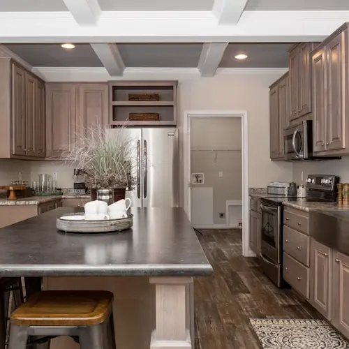 Elegance meets modern design in Kennesaw Elite kitchen with dark, floor-to-ceiling cabinets, large eat-in island and coffered ceiling.
