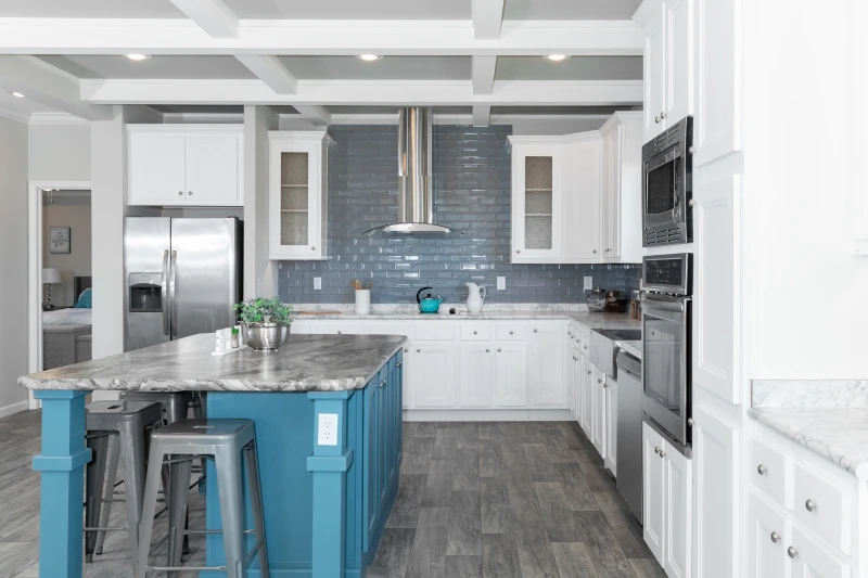 A contemporary style kitchen with a large blue island and subway tile backsplash