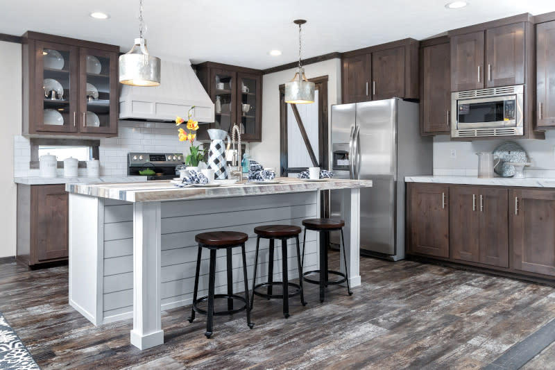 Kitchen of a manufactured home with dark cabinetry and a large island.