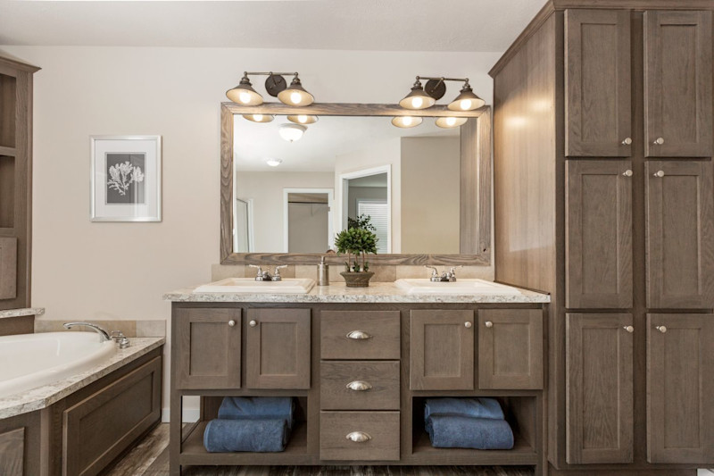 A contemporary style bathroom with storage cabinets, a double sink vanity and soaking tub.