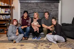 Shannon Navarrette posing with her kids and grandson in front of her fireplace