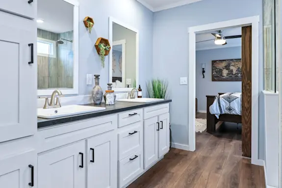 The primary bathroom of [model name] features dual sinks and a walk-in shower.