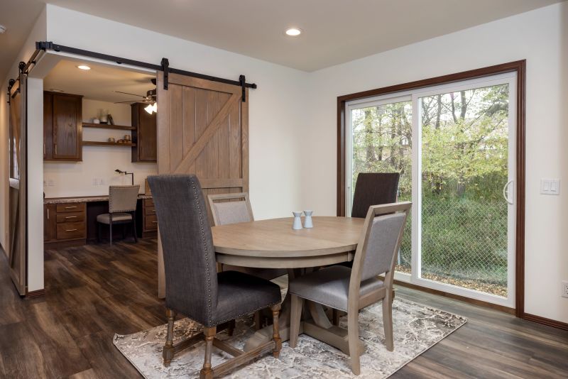Dining room in kitchen near two sliding doors with a kitchen table set up on a rug.