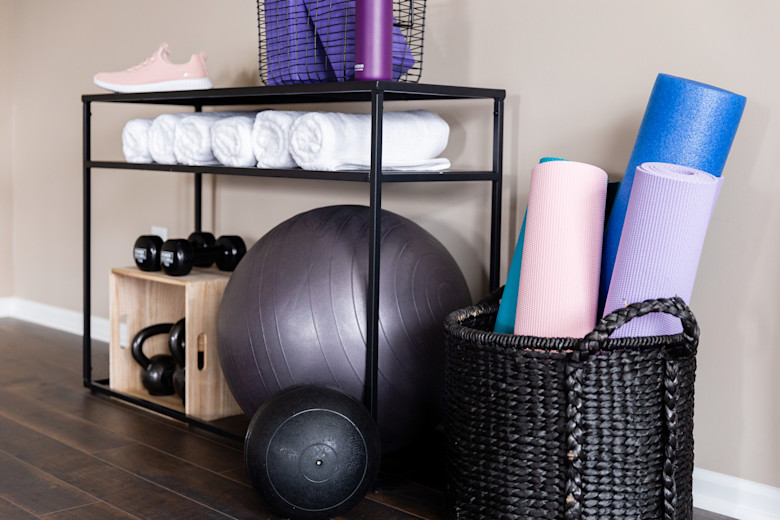 Bright colored home gym equipment organized on a shelf in a manufactured home flex space.