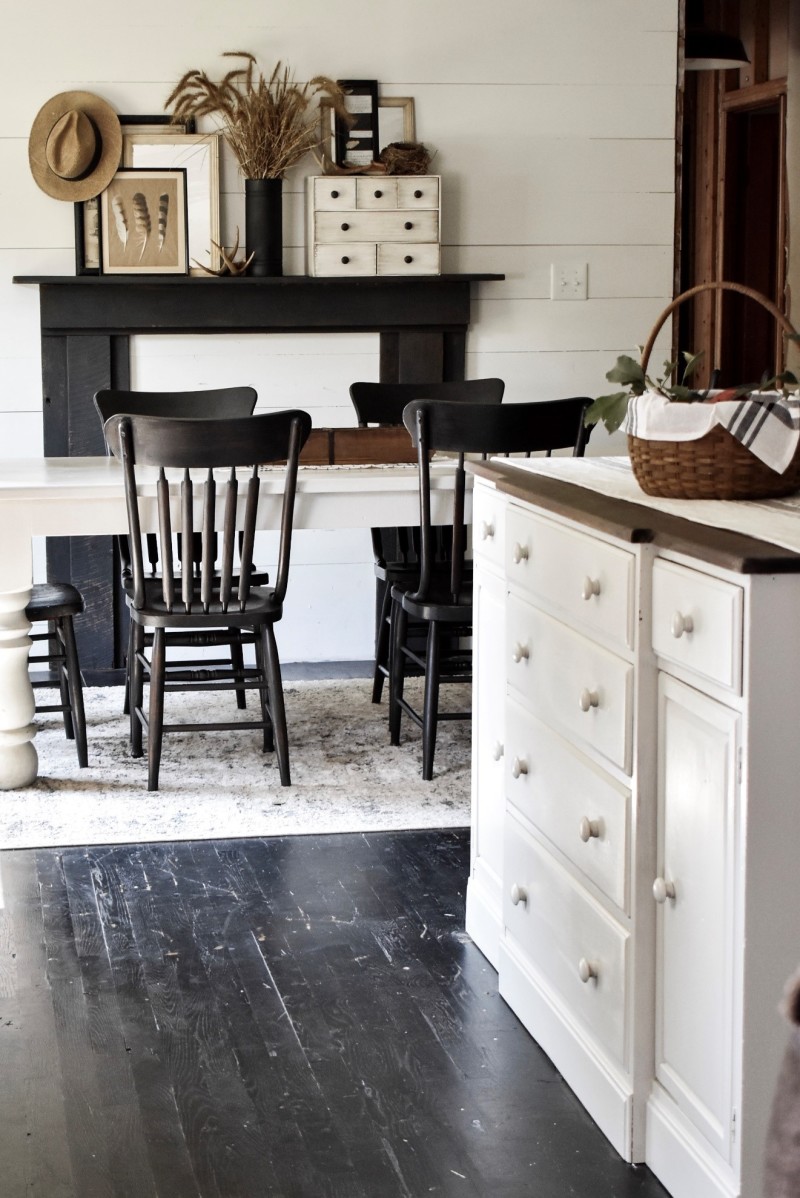 farmhouse kitchen with black floors and shiplap walls