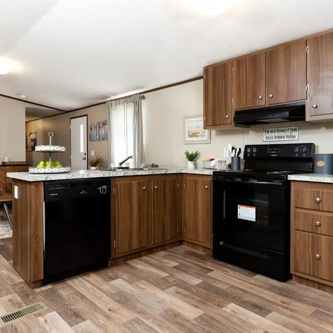 Rich wood style cabinetry and black appliances create a sleek look in the Grand kitchen. 