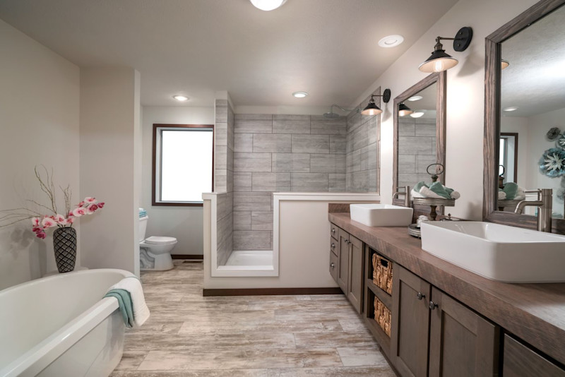 A primary suite bathroom with a separate soaking tub and shower and a large double sink vanity.