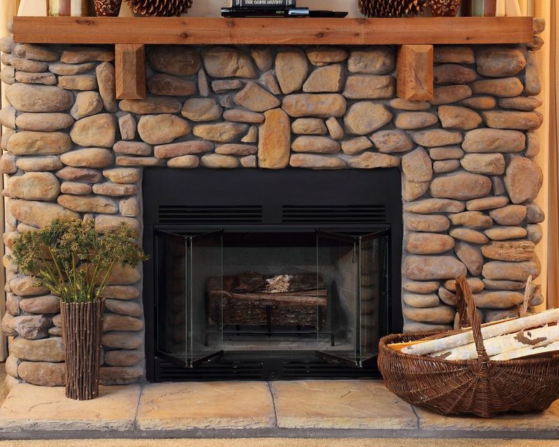 modular home wood burning fireplace with stones and wood.