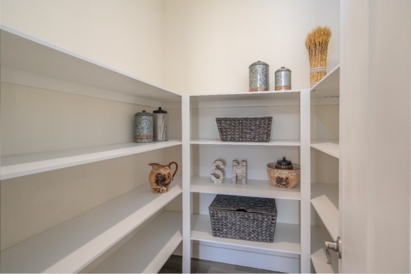 White walk-in pantry with shelving and items sitting on shelves in the Coronado manufactured home.
