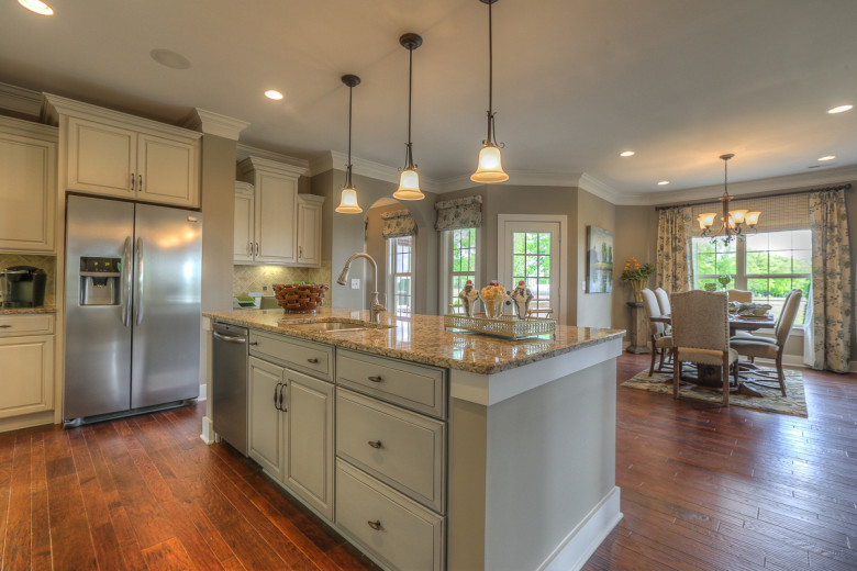 Interior view of a large, white open kitchen with an oversized island