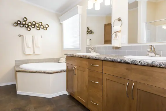 The [model name] features a primary bathroom with a garden tub and a granite-style counter top.