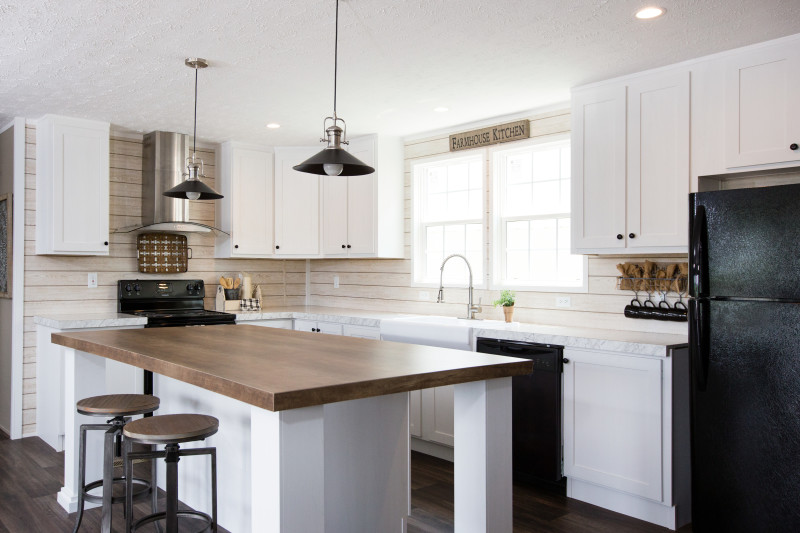 Manufactured home kitchen with white cabinetry and a large kitchen island.